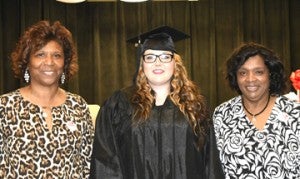 The GED graduate from Webster County is shown with her instructors.