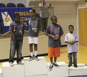 Michael Murray/Americus Times-Recorder:   Competitors from Sumter County take the dais to receive their awards on Oct. 14 at the GSW Storm Dome in Americus after competing in basketball-related challenges at the Special Olympic Games.