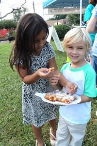 A brother and sister enjoy a plate of funnel cakes during the festival.