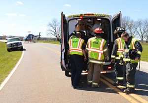 Personnel with Sumter County Fire & Rescue load one of the accident victims into a Gold Star ambulance for transport to Phoebe Sumter Medical Center, while an Air Evac helicopter in the background awaits another victim for transport to a Macon hospital.